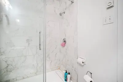 a bathroom with a shower with a glass door at Bienvenue dans votre havre de paix à Griffintown in Montréal