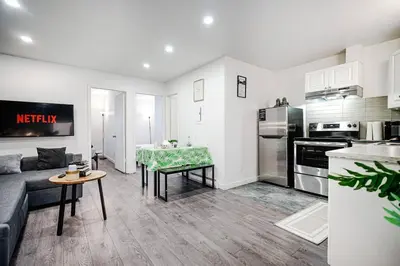 a kitchen and living room with a couch and a table at Bienvenue dans votre havre de paix à Griffintown in Montréal