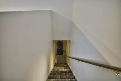 a staircase in a building with a white wall at Downtown Sherby - Central, Parking, King Bed, Sleeps 3 in Sherbrooke