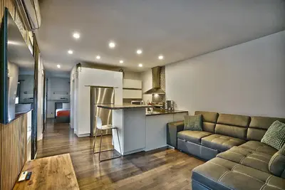 a kitchen and a living room with a couch and a table at Downtown Sherby - Central, Parking, King Bed, Sleeps 3 in Sherbrooke