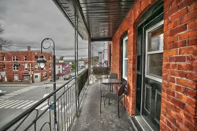 a balcony with a table and chairs on a building at Downtown Sherby - Central, Parking, King Bed, Sleeps 3 in Sherbrooke