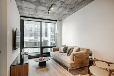 a living room with a couch and a large window at Le Mont Apartments in Montréal