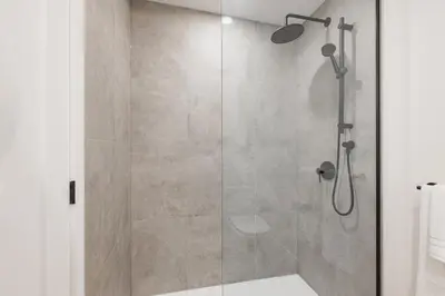 a shower with a glass door in a bathroom at Le Mont Apartments in Montréal