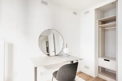 a mirror on a white desk with a chair at Le Mont Apartments in Montréal