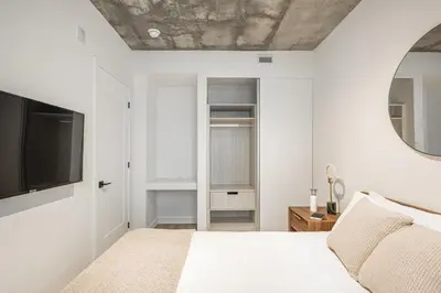 a bedroom with a bed and a tv on the wall at Le Mont Apartments in Montréal