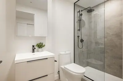 a bathroom with a shower and a toilet and a sink at Le Mont Apartments in Montréal