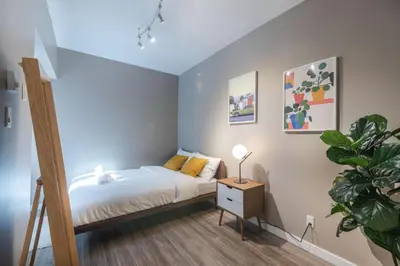 a small bedroom with a bed and a plant at Castle Lofts Apartments in Montréal