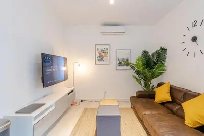 a living room with a couch and a tv on a wall at Castle Lofts Apartments in Montréal