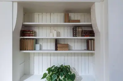 a book shelf in a kitchen with a plant at Castle Lofts Apartments in Montréal