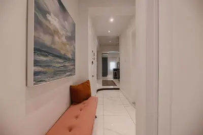 a hallway with a bench and a painting on the wall at Saint Laurent Signature Hotel Montreal in Montréal