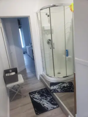 a bathroom with a shower with two mats on the floor at SylverPrud in Beauceville