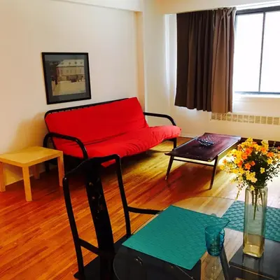 a living room with a red couch and a table at Stylish Montreal Apartment Comfortable Stay in the Golden Square Mile in Montréal