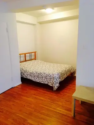 a bedroom with a bed in a room with wooden floors at Stylish Montreal Apartment Comfortable Stay in the Golden Square Mile in Montréal
