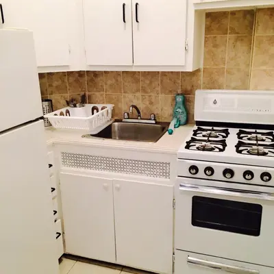a kitchen with a white stove and a sink at Stylish Montreal Apartment Comfortable Stay in the Golden Square Mile in Montréal