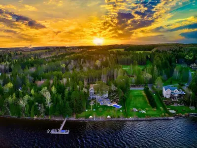 an aerial view of a house on an island in the water at Estello Suites & Spa in Lac-Mégantic