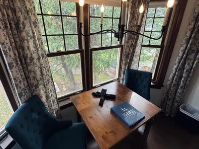 a table with a book on it in front of a window at Estello Suites & Spa in Lac-Mégantic