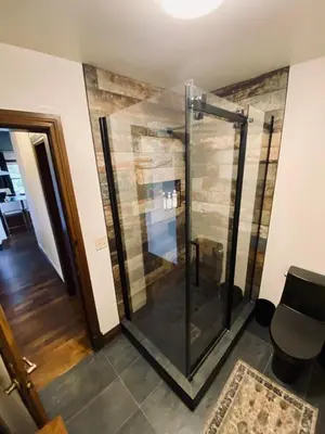 a glass shower in a room with a table at Estello Suites & Spa in Lac-Mégantic