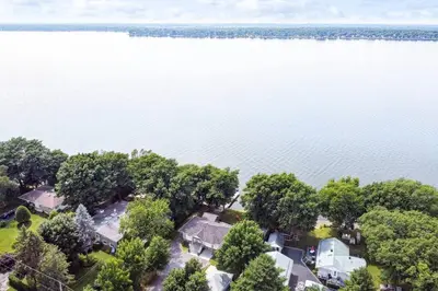 an aerial view of a house in the middle of the water at Sunset Heaven - Modern Lake House with Spa in Venise-en-Québec