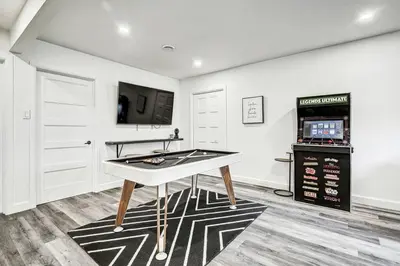 a ping pong table in a room with a tv at Sunset Heaven - Modern Lake House with Spa in Venise-en-Québec