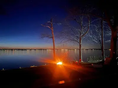 a view of a lake at night with a bench and trees at Sunset Heaven - Modern Lake House with Spa in Venise-en-Québec
