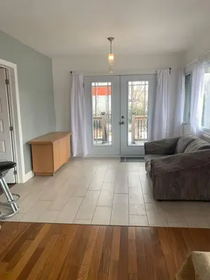 a living room with a couch and a table at Appartment with Hot Tub and Backyard and Free Parking in Saint-Hyacinthe