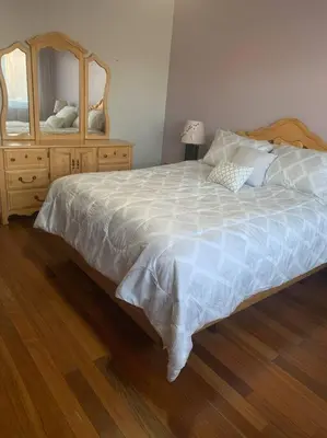 a bedroom with a bed with a dresser and a mirror at Appartment with Hot Tub and Backyard and Free Parking in Saint-Hyacinthe