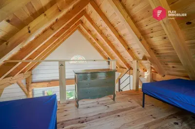 a room with a bed and a desk in a attic at L'Ermite - Rustique Écoresponsable Dans la nature in Notre-Dame-Des-Bois