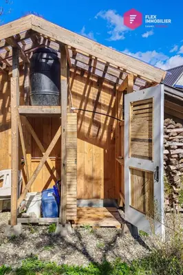 a wooden shed with a large bucket at L'Ermite - Rustique Écoresponsable Dans la nature in Notre-Dame-Des-Bois