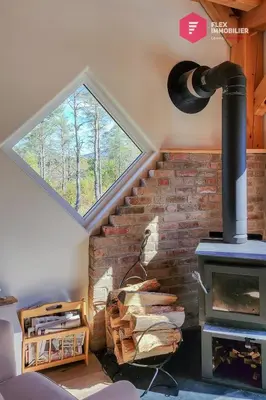 a room with a brick fireplace and a window at Le Pèlerin - Rustique Écoresponsable En nature in Notre-Dame-Des-Bois