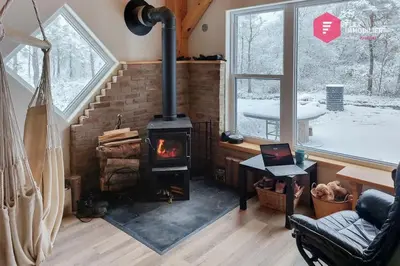 a living room with a fireplace and a stove at Le Pèlerin - Rustique Écoresponsable En nature in Notre-Dame-Des-Bois