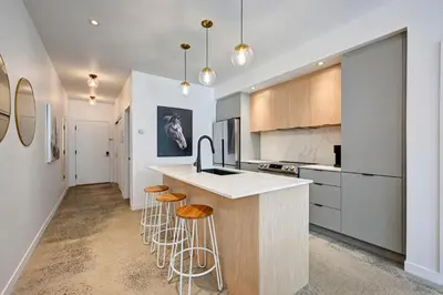 a kitchen with a counter and stools in it at Élégant 2ch 2sdb Beau Quartier de Montréal présenté par TripMontreal IV in Montréal