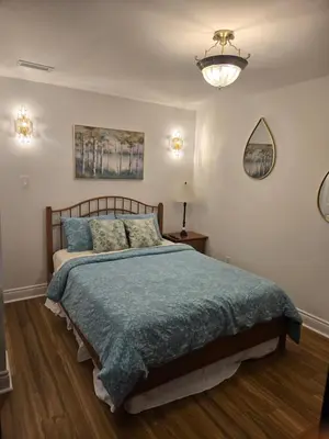 a bedroom with a bed with a blue comforter at Doux cocon in Saint-Jean-sur-Richelieu