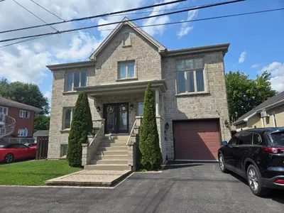 a house with a car parked in front of it at Doux cocon in Saint-Jean-sur-Richelieu
