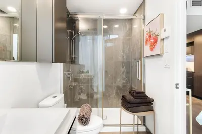a bathroom with a shower and a toilet at Luxury Apartments with View & Indoor Heated Pool in Montréal
