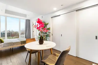 a room with a table with a vase of flowers at Luxury Apartments with View & Indoor Heated Pool in Montréal