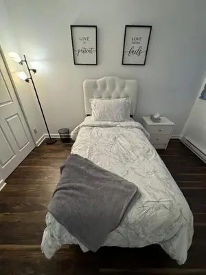 a bedroom with a bed and two pictures on the wall at Ste-Rose 2 bedroom apt in Laval