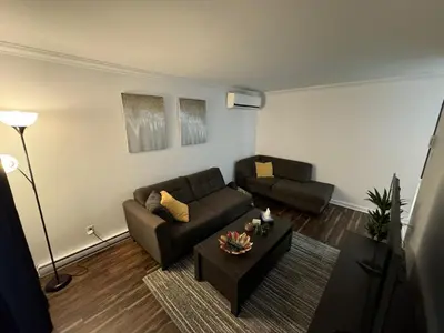 a living room with a couch and a table at Ste-Rose 2 bedroom apt in Laval