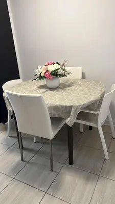 a table with two chairs and a vase of flowers on it at Ste-Rose 2 bedroom apt in Laval