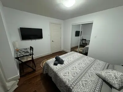 a bedroom with a bed and a flat screen tv at Amazing 3-Bedrooms in Rosemont - Montreal in Montréal