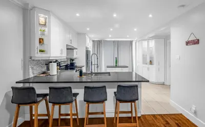 a kitchen with a island with four chairs around it at Amazing 3-Bedrooms in Rosemont - Montreal in Montréal