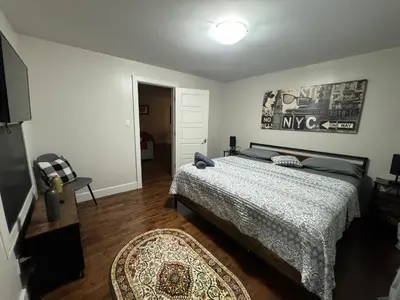 a bedroom with a bed and a table and a chair at Amazing 3-Bedrooms in Rosemont - Montreal in Montréal