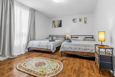 a bedroom with two beds and a rug at Amazing 3-Bedrooms in Rosemont - Montreal in Montréal