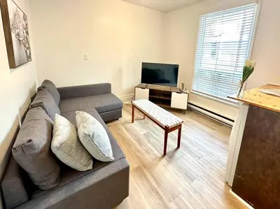 a living room with a couch and a tv at 3-Bedroom Apt - Low monthly rate - Le Plateau in Montréal