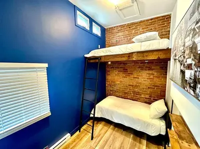 a room with two bunk beds and a brick wall at 3-Bedroom Apt - Low monthly rate - Le Plateau in Montréal