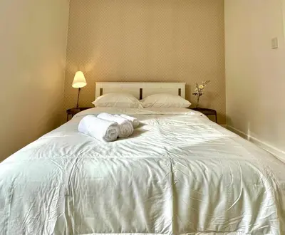 a large white bed with two towels on it at 3-Bedroom Apt - Low monthly rate - Le Plateau in Montréal