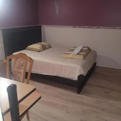 a bedroom with a bed and a table and a chair at Chambre privée avec clefs intime et privée in Montréal