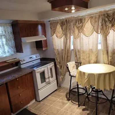 a kitchen with a table and a table and a stove at Chambre vu à couper le souffle in Montréal