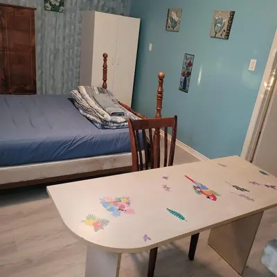 a room with a table and a bed and a table and chair at Chambre vu à couper le souffle in Montréal