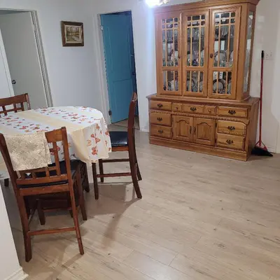 a dining room with a table and chairs and a dresser at Chambre vu à couper le souffle in Montréal