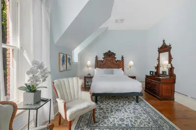 a bedroom with a bed and a chair at Manoir Sweetsburg in Cowansville